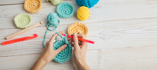 knitting crochet  woman hands top view. colorful balls of yarn blue, yellow and orange. Relaxing...