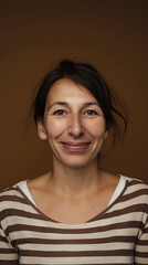  Portrait of a woman smiling warmly against a brown background