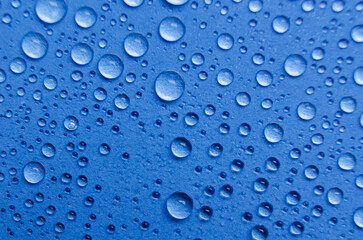 Rain water droplets on blue cover background. Water droplets concept