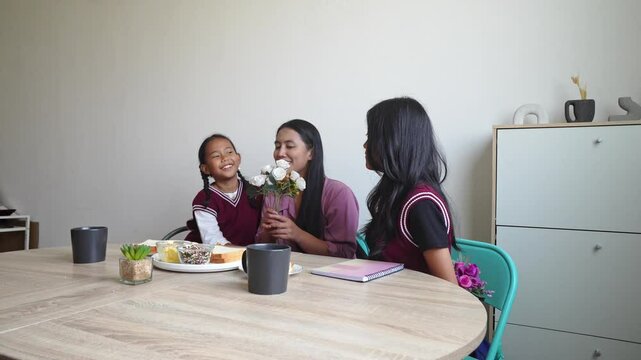 Two Young Asian Daughters Surprising Their Mother With Flowers On Mother Day Celebration