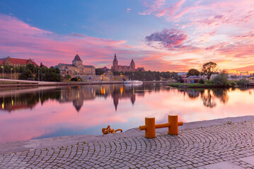 Sunset view of the Szczecin riverfront along the Oder River in Poland, featuring the illuminated...