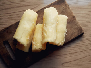 cooked and cut cassava on board and wooden background