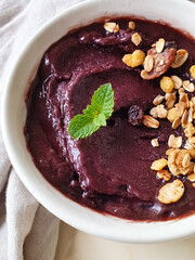 Iced açaí with granola and mint in white bowl 