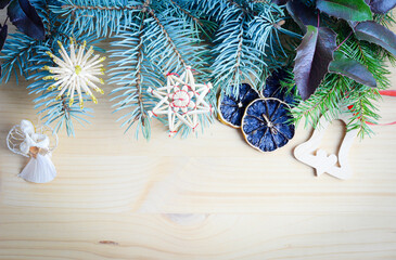 Christmas frame of spruce, natural christmas decorations on wooden background. Copy space. New Year lights. Flat lay.