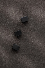 Three empty rectangles on black sand, place for text, letters, word. Tiles or black dices on a...
