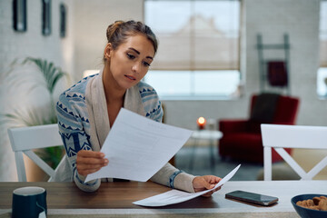 Young woman going through documents at home.