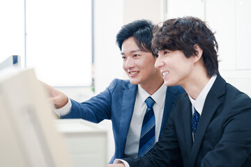 Fototapeta premium オフィスで議論をする2人の男性ビジネスマン