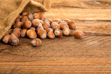 Hazelnuts in burlap bag on rustic table