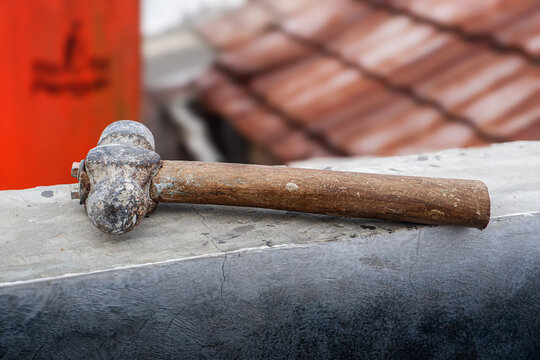 A hammer lying on the fence wall