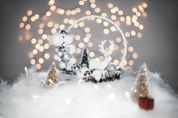 Christmas deoration concept on holidays with a porcelain derr, white fake snow for a festive december. In the background are bokeh balls made of lights