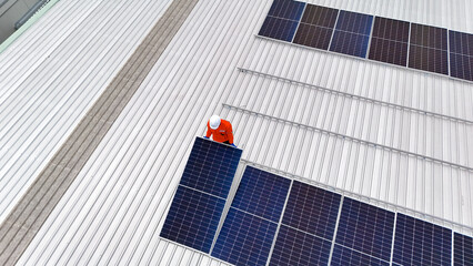 Builder mounting photovoltaic solar modules on roof of house. Back view of man engineer in helmet installing solar panel system outdoors. Concept of alternative and renewable energy. © FotoArtist