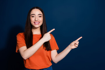 Photo of adorable gorgeous woman wear stylish orange clothes introduce empty space isolated on dark blue color background