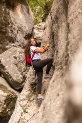 A strong woman going for a hike on a via ferrata in the nature