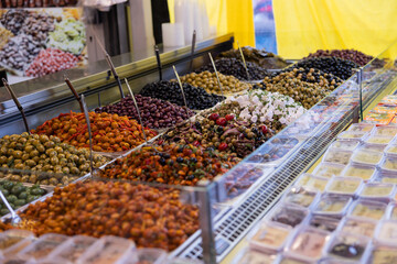 Pickled black and green olives, marinated in olive oil or feta cheese, with spices and onions. Mediterranean healthy food. Haagse Market in The Hague, Netherlands.