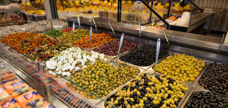 Pickled black and green olives, marinated in olive oil or feta cheese, with spices and onions. Mediterranean healthy food. Haagse Market in The Hague, Netherlands. - Powered by Adobe