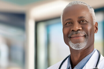 Close up of a handsome, elderly, black doctor smiling, wearing a white coat and a stethoscope around his neck. Hospital background. Copy space. Space for text.