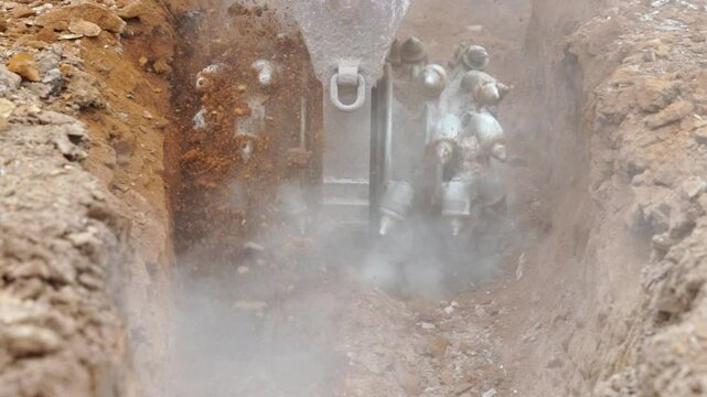 Exploring the Power of Heavy Machinery Rockwheel During Excavation in Muddy Terrains at Construction Site