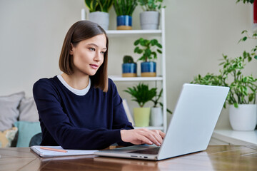 Young female using computer laptop for studying working