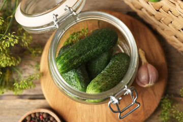 Homemade pickles. Fresh cucumbers in jar, dill and peppercorns on wooden table, flat lay