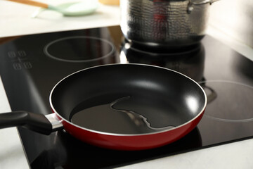 Frying pan with oil on cooktop in kitchen, closeup