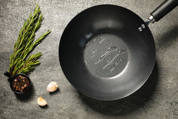 Frying pan with oil and spices on gray textured table, flat lay