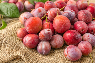 Pile of tasty ripe plums on table, closeup