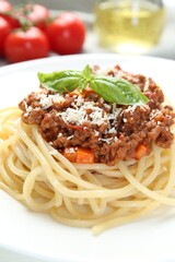 Delicious pasta bolognese with basil on table, closeup