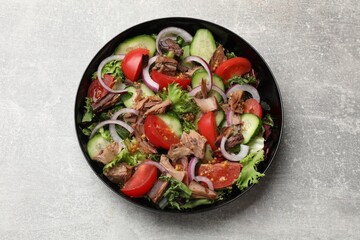Delicious fresh tuna salad on light grey table, top view