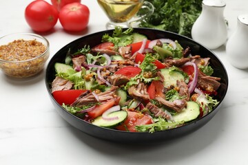 Delicious fresh tuna salad and ingredients on white marble table, closeup