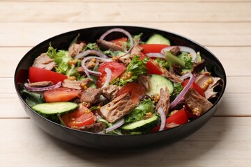 Delicious fresh tuna salad on wooden table, closeup