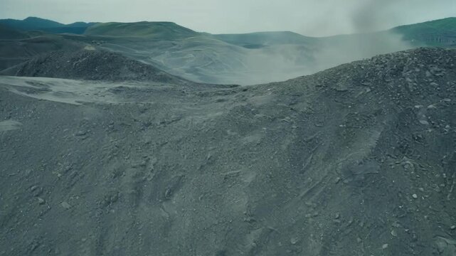 Lifeless gray landscape, like mars, shows the impact of industrial waste on the environment, with toxic hills symbolizing pollution and climate change