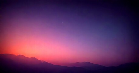 Obraz premium A serene night sky with a gradient of purple and orange hues, featuring a silhouette of mountains in the distance