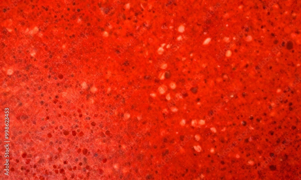 Aufkleber a close-up view red, speckled surface, possibly a stone or concrete floor, with a textured and irreg