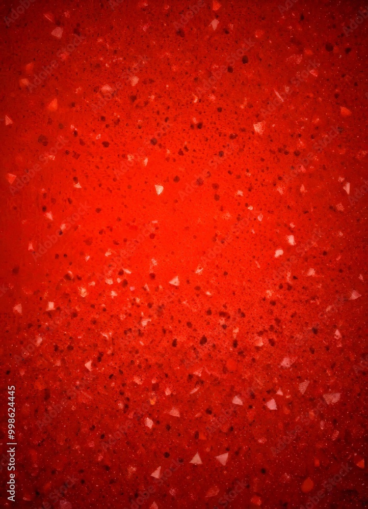 Poster a close-up view red surface with small, irregularly shaped white and black speckles scattered across