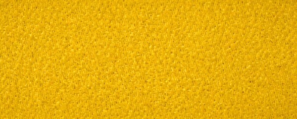 Fototapeta premium A close-up view textured yellow fabric surface, resembling a woven or knitted material