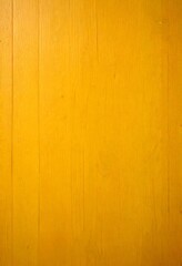 Obraz premium A close-up view wooden surface with a warm yellow hue, featuring a textured and slightly worn appearance