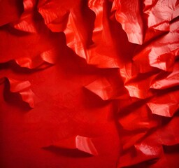 a close-up view red fabric with a crumpled texture, creating a sense of depth and movement