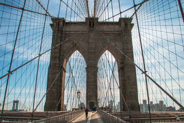 Personas cruzando el puente de Brooklyn en la zona peatonal. Paisaje urbano en una fr&iacute;a ma&ntilde;ana de oto&ntilde;o. Al fondo, los edificios de Brooklyn a orillas del r&iacute;o Este. Nueva York, Estados Unidos. 2019.