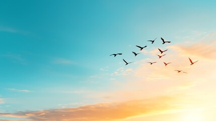 A flock of birds flying in formation against a vibrant blue sky and a warm sunset.