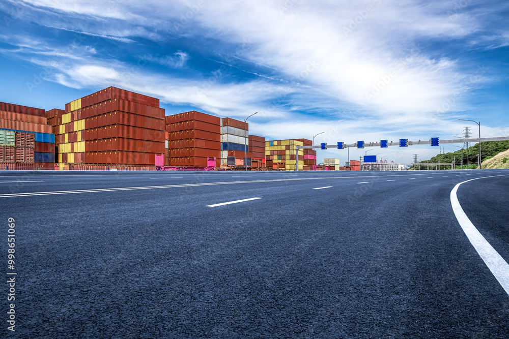 Aufkleber stacked containers and empty asphalt road at the port