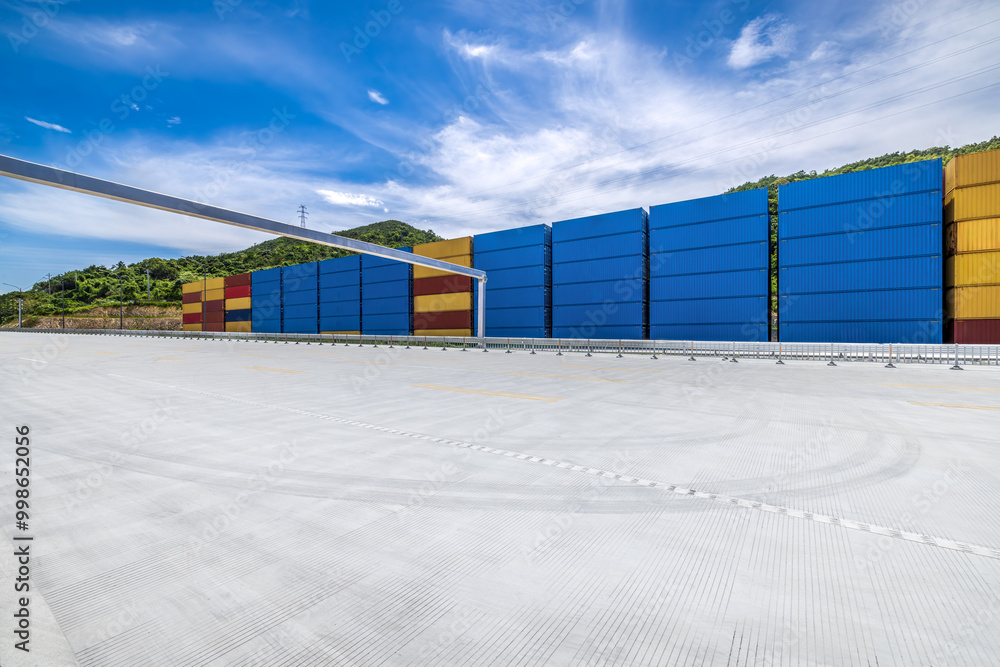Aufkleber Stacked containers and empty asphalt road at the port