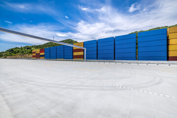 Stacked containers and empty asphalt road at the port