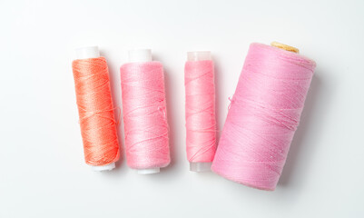 Pink thread spools on white background.