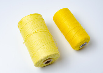 Yellow thread spools on white background.
