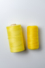 Yellow thread spools on white background.