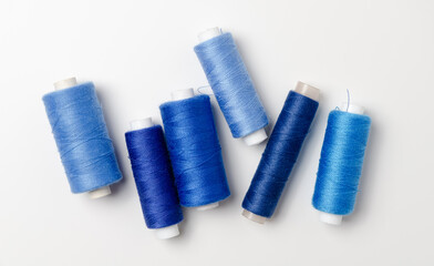 Blue thread spools on white background.