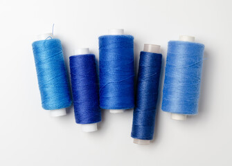 Blue thread spools on white background.
