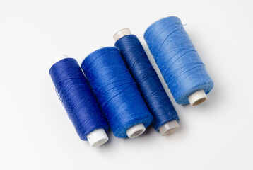 Blue thread spools on white background.