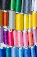 Top view of many colorful thread spools background