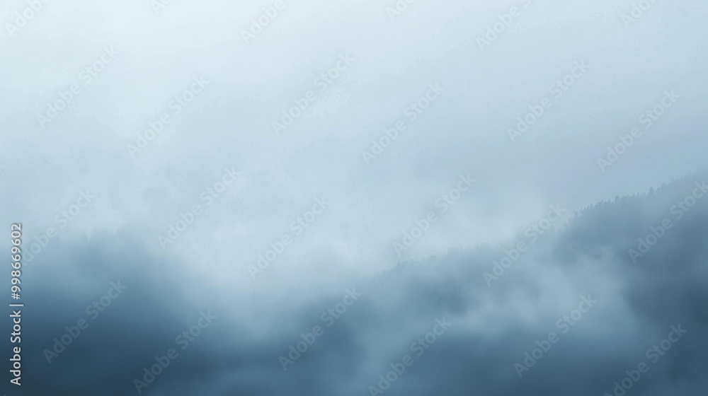 Aufkleber dense fog is covering the mountain peaks on a cloudy day, creating a mysterious and atmospheric scen